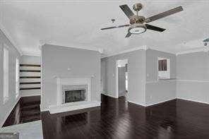 unfurnished living room with crown molding and dark hardwood / wood-style flooring