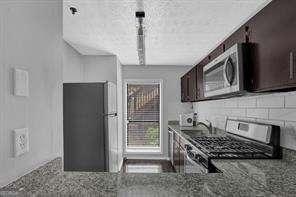 kitchen with dark brown cabinets, stove, and sink