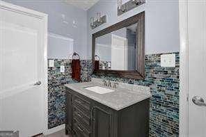 bathroom featuring vanity and tile walls