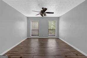 unfurnished room with ceiling fan and dark hardwood / wood-style floors