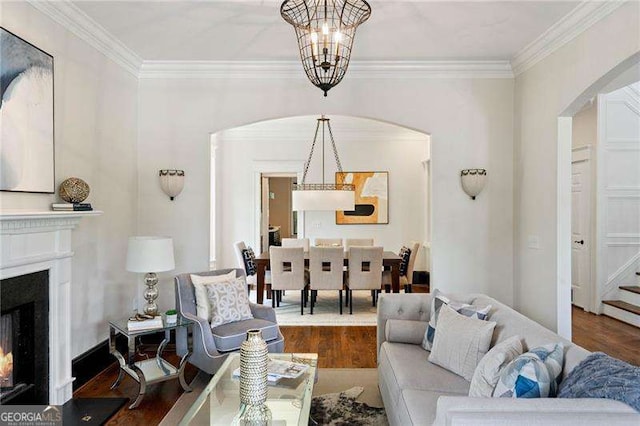 living room featuring a notable chandelier, crown molding, and dark wood-type flooring