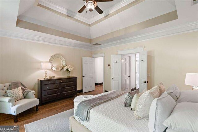 bedroom with ceiling fan, a raised ceiling, and ornamental molding