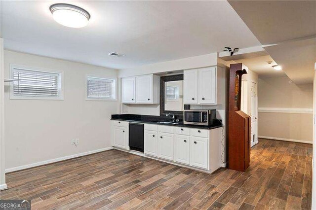 kitchen with white cabinetry, dishwasher, dark hardwood / wood-style floors, and sink