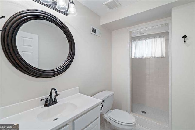 bathroom featuring vanity, toilet, and tiled shower