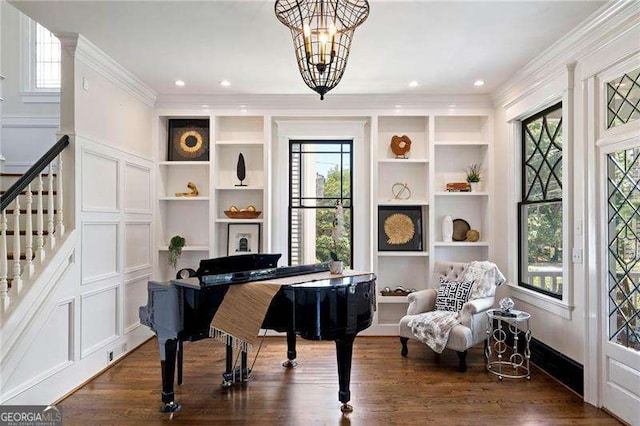 living area featuring a healthy amount of sunlight, dark wood-type flooring, and an inviting chandelier