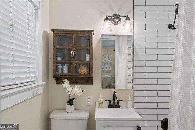 bathroom featuring vanity, curtained shower, and toilet