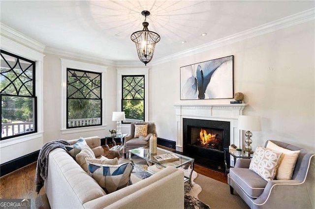 living room with plenty of natural light, wood-type flooring, crown molding, and a chandelier