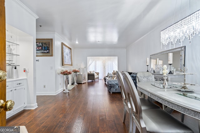 dining room featuring a chandelier, crown molding, and dark wood-type flooring