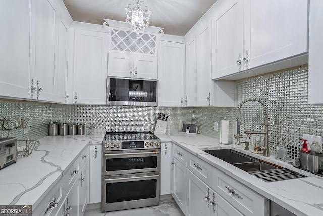 kitchen with white cabinets, appliances with stainless steel finishes, and tasteful backsplash