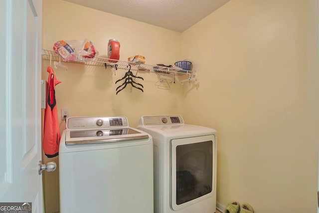 laundry room featuring a textured ceiling and separate washer and dryer