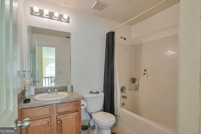 full bathroom featuring vanity, shower / bath combo, a textured ceiling, and toilet