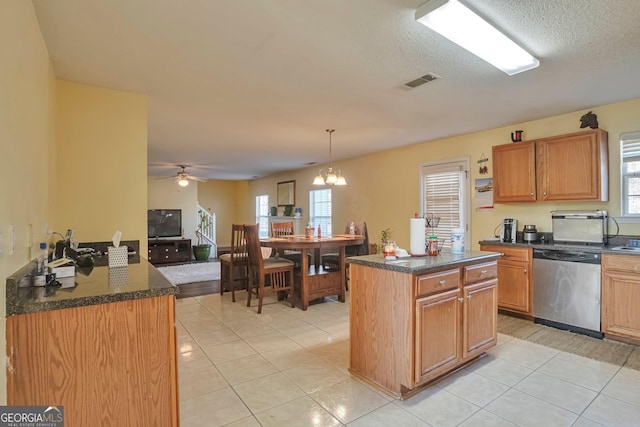 kitchen featuring a textured ceiling, light tile patterned floors, dishwasher, a center island, and hanging light fixtures