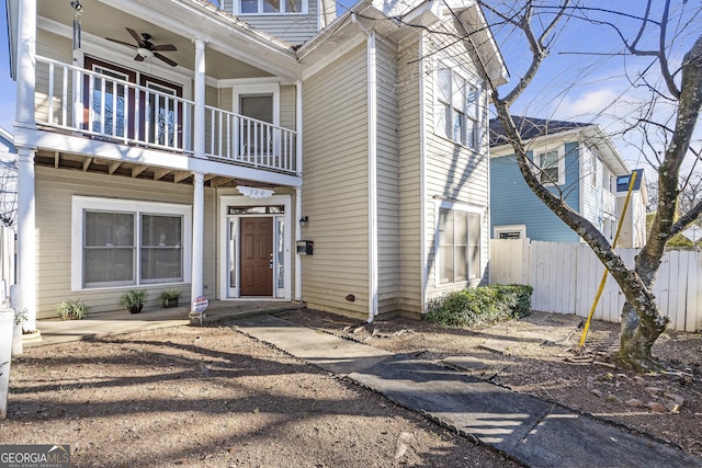 view of front of house featuring ceiling fan and a balcony