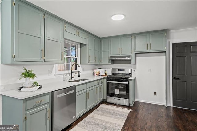 kitchen with appliances with stainless steel finishes, dark hardwood / wood-style flooring, and sink