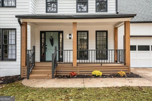 view of exterior entry featuring covered porch and a garage