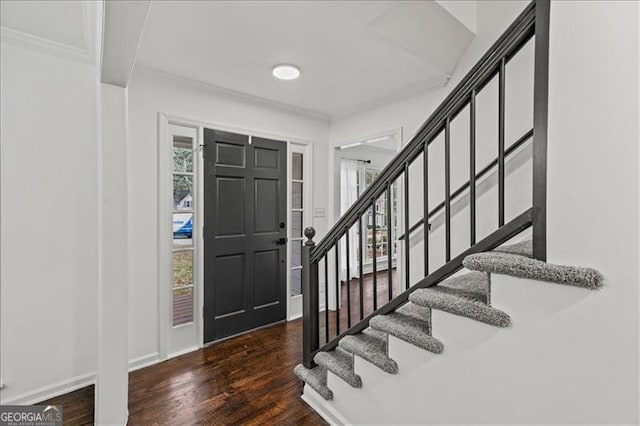 entryway with dark hardwood / wood-style floors and ornamental molding