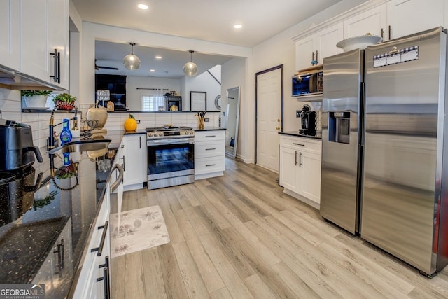 kitchen with tasteful backsplash, white cabinetry, and appliances with stainless steel finishes