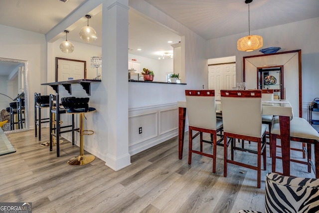 dining area featuring ornate columns and light hardwood / wood-style floors