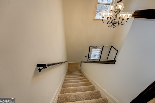 stairway featuring an inviting chandelier and carpet floors