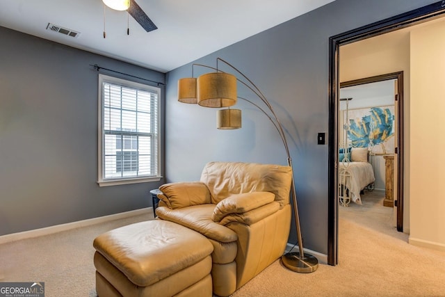 sitting room featuring light colored carpet and ceiling fan