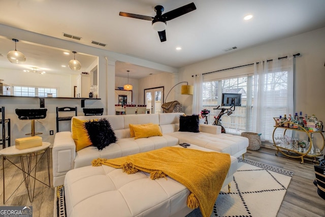 living room with hardwood / wood-style flooring, ceiling fan, and french doors