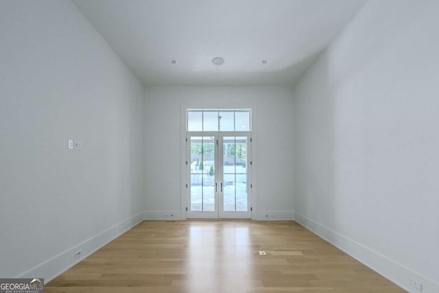 spare room with french doors and light wood-type flooring