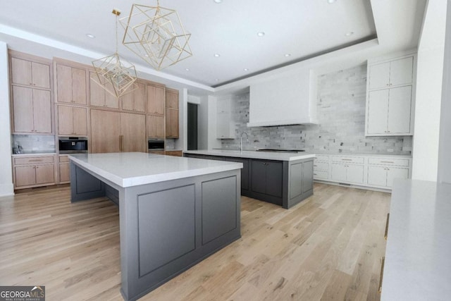 kitchen with decorative backsplash, a kitchen island, and hanging light fixtures