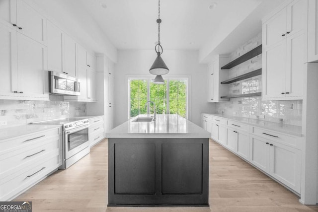 kitchen featuring white cabinets, electric stove, an island with sink, tasteful backsplash, and decorative light fixtures