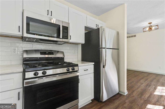 kitchen featuring white cabinets, decorative backsplash, stainless steel appliances, and light stone counters