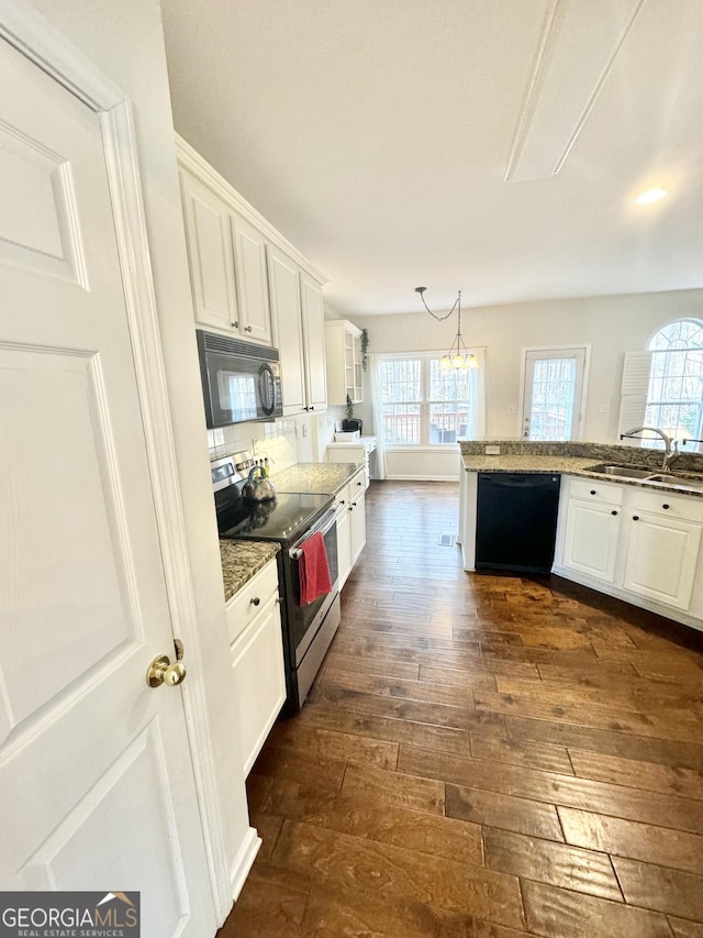 kitchen featuring dark wood-type flooring, sink, black appliances, white cabinetry, and hanging light fixtures