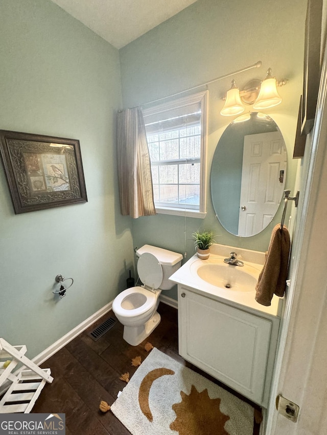 bathroom featuring vanity, wood-type flooring, and toilet