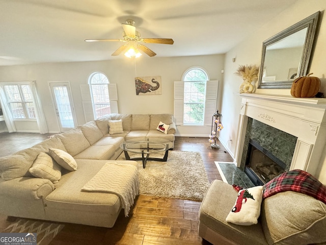 living room featuring ceiling fan, a fireplace, and dark hardwood / wood-style floors