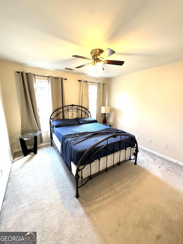 bedroom with multiple windows, ceiling fan, and carpet floors