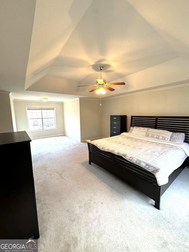 bedroom with a raised ceiling, ceiling fan, light carpet, and vaulted ceiling