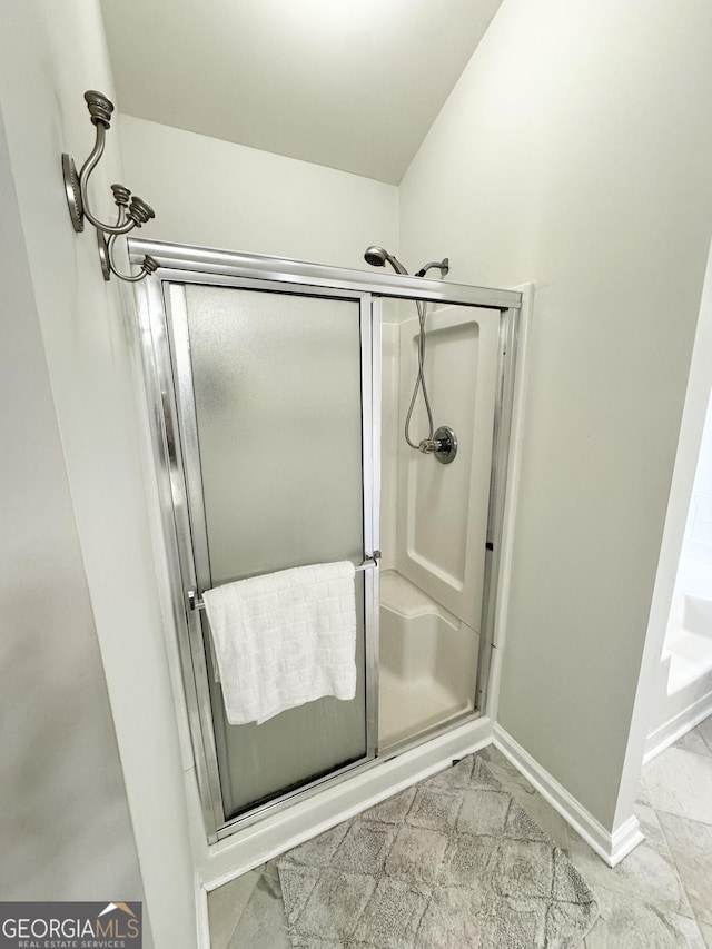 bathroom featuring a shower with door