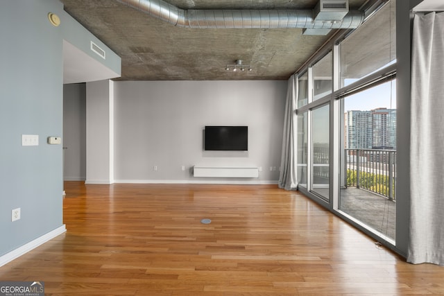 unfurnished living room with hardwood / wood-style floors and expansive windows