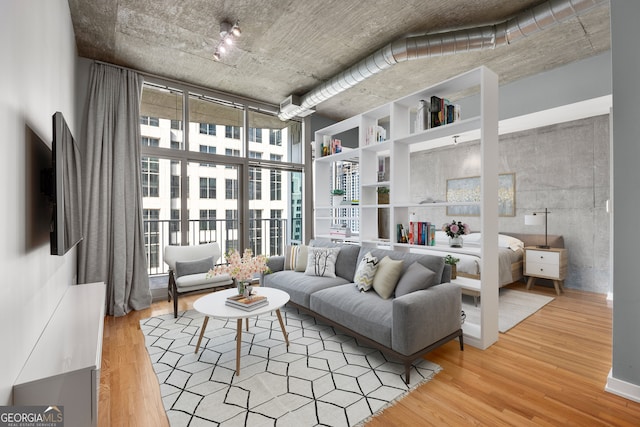 living room featuring floor to ceiling windows, wood-type flooring, and a high ceiling