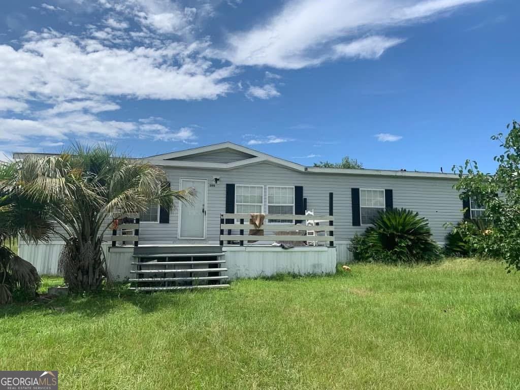 back of house featuring a yard and a wooden deck