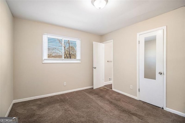 unfurnished bedroom with dark carpet