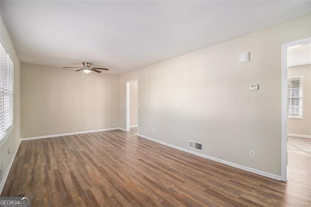 spare room with dark hardwood / wood-style floors and ceiling fan