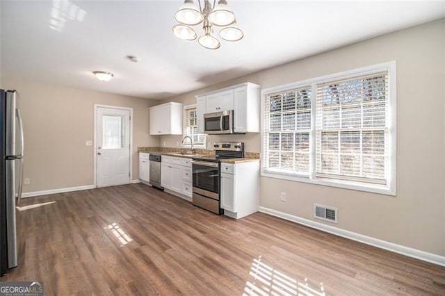 kitchen with hardwood / wood-style flooring, sink, white cabinetry, and stainless steel appliances