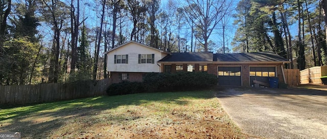 tri-level home featuring a garage and a front yard