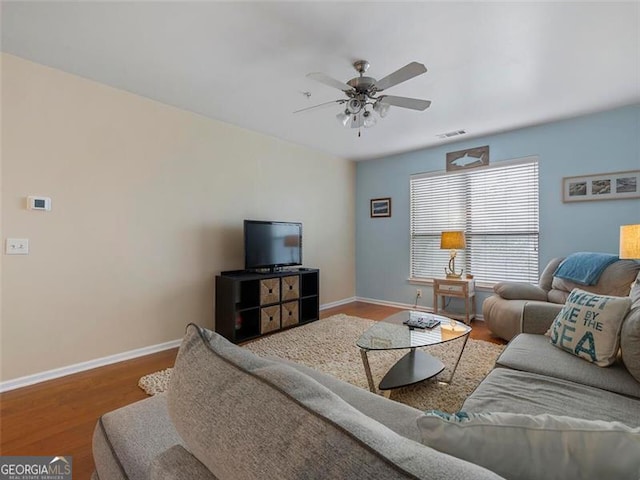 living room featuring hardwood / wood-style floors and ceiling fan