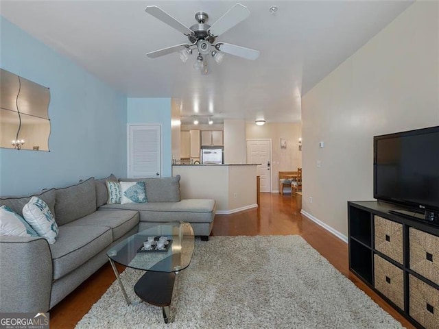 living room featuring wood-type flooring and ceiling fan with notable chandelier