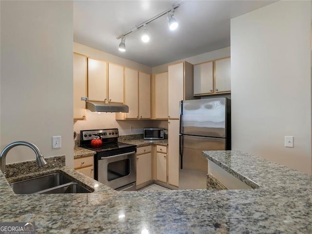 kitchen featuring stone counters, appliances with stainless steel finishes, light brown cabinets, and sink