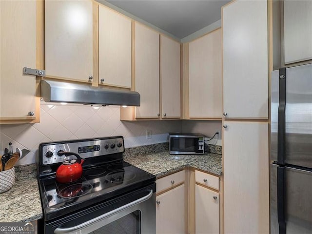 kitchen with backsplash, light stone counters, and stainless steel appliances