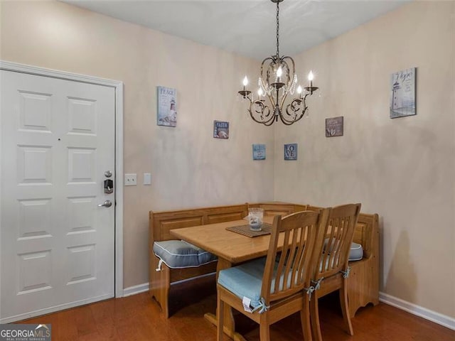 dining space with dark hardwood / wood-style floors and an inviting chandelier