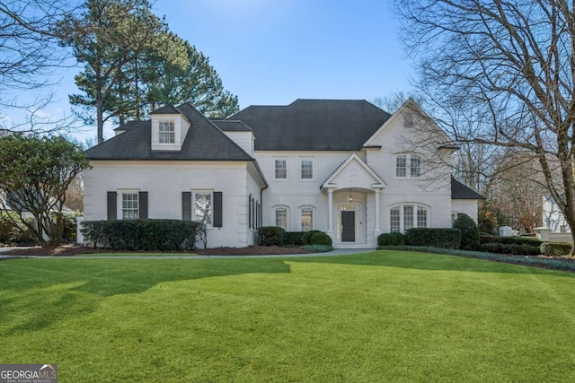 french country inspired facade featuring a front yard