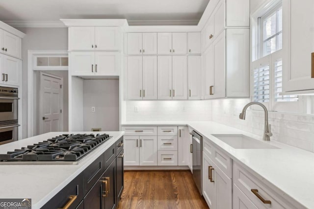 kitchen featuring stainless steel appliances, white cabinetry, tasteful backsplash, and sink