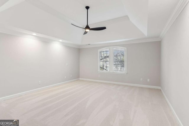 carpeted spare room featuring a tray ceiling, ceiling fan, and ornamental molding